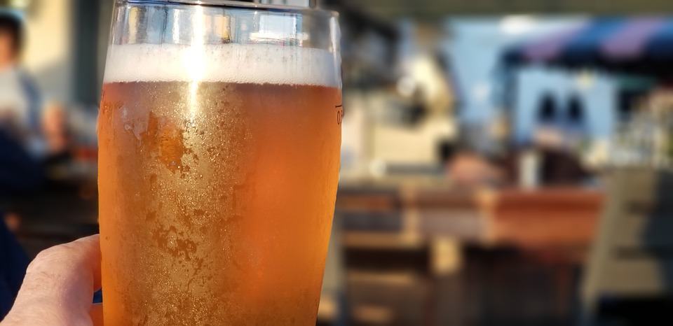 Man Showing his Chilled Glass Filled with Treehouse Brewery Beverage at their Dining Area