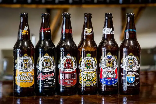  Unchilled Six Bottles of Belching Beaver Brewery Variants on a Wooden Table Inside the Dining Area