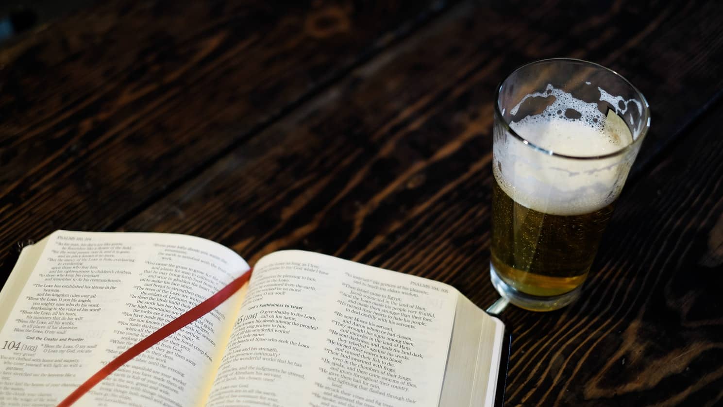 book and a glass of beer on a table
