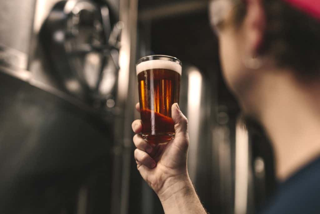 man holding a glass beer