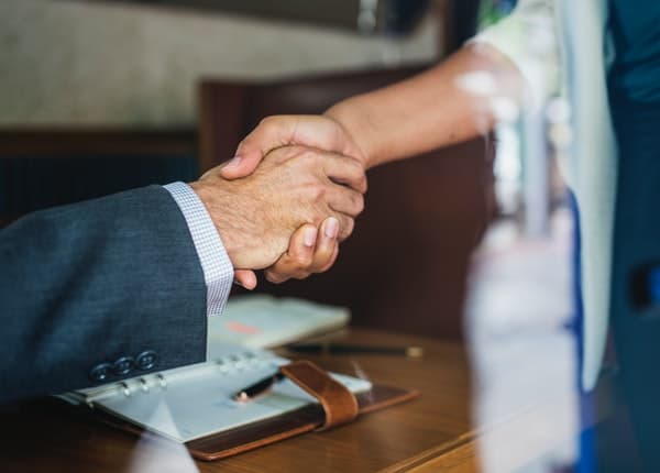 person in business shaking the hands of another person