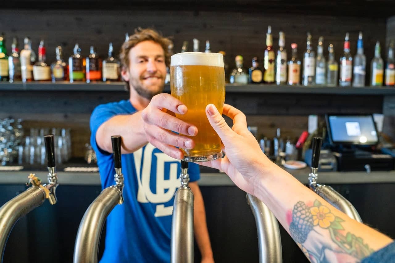 Man handling person glass of beer